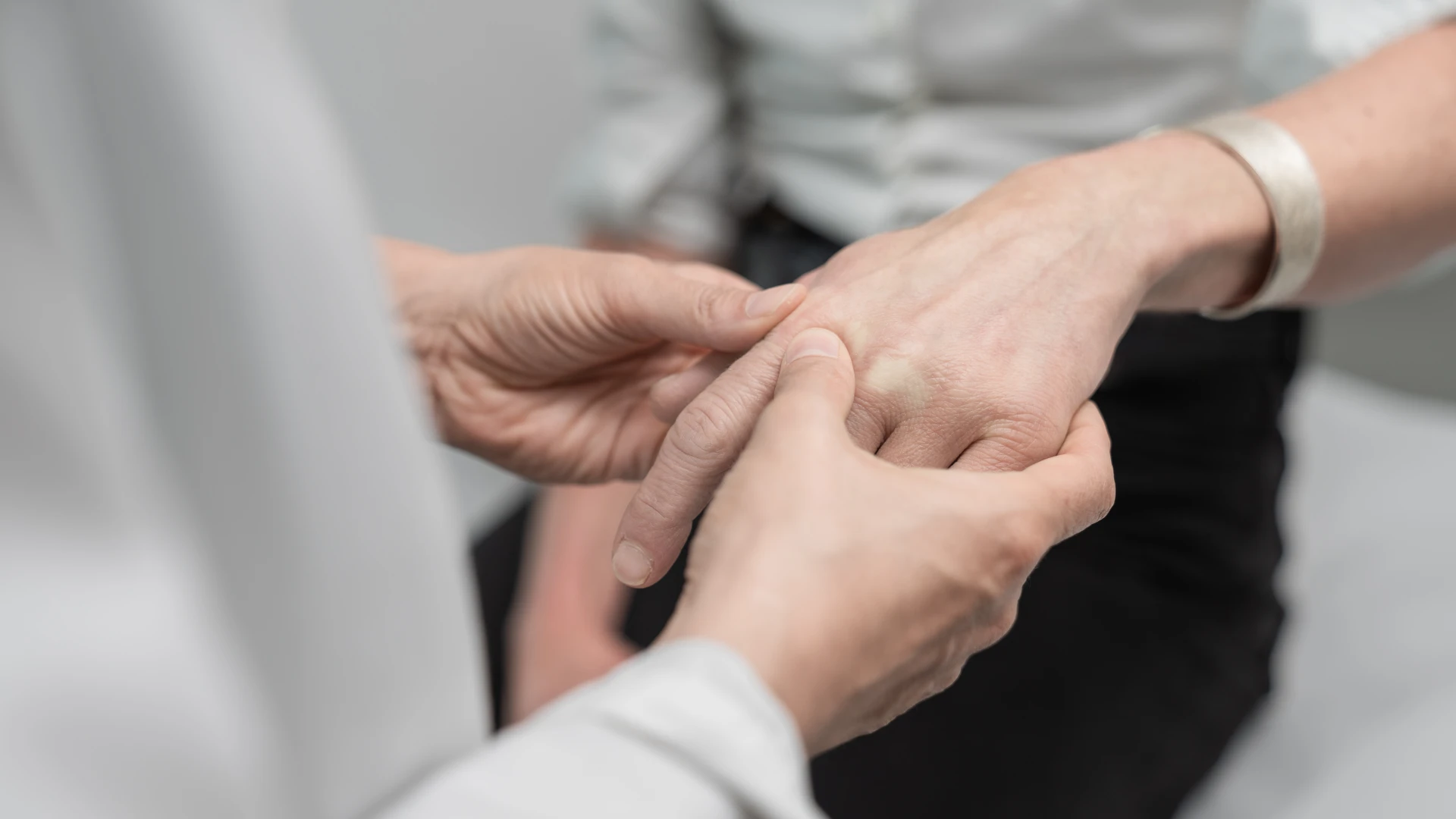 Artrite reumatoide Un medico esamina le articolazioni delle dita di una paziente affetta da artrite reumatoide