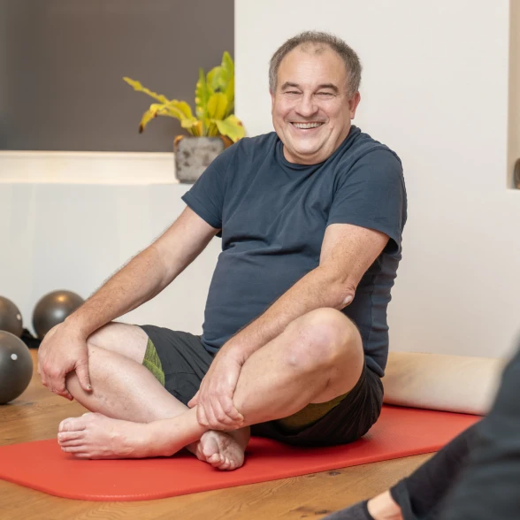 Un uomo durante una lezione di ginnastica Un anziano seduto a gambe incrociate durante un corso di attività fisica organizzato dalla Lega contro i reumatismi