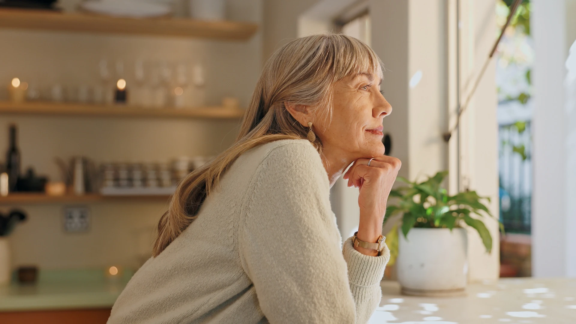 Valutazione del rischio di osteoporosi Donna pensierosa davanti alla finestra