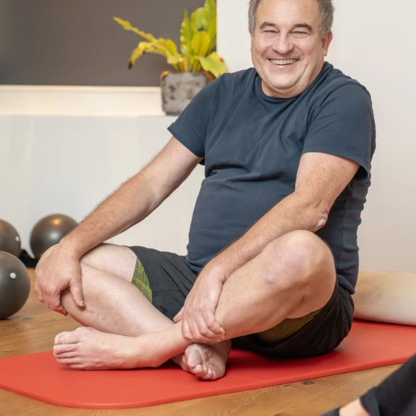 Un uomo durante una lezione di ginnastica Un anziano seduto a gambe incrociate durante un corso di attività fisica organizzato dalla Lega contro i reumatismi